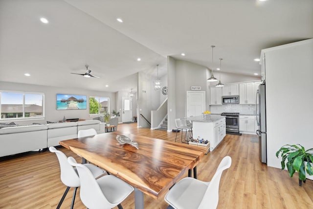 dining room with vaulted ceiling, ceiling fan, and light hardwood / wood-style flooring