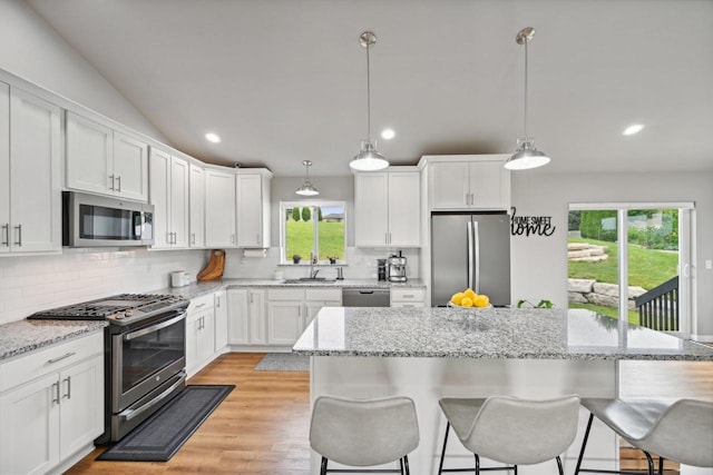 kitchen with hanging light fixtures, white cabinets, and appliances with stainless steel finishes