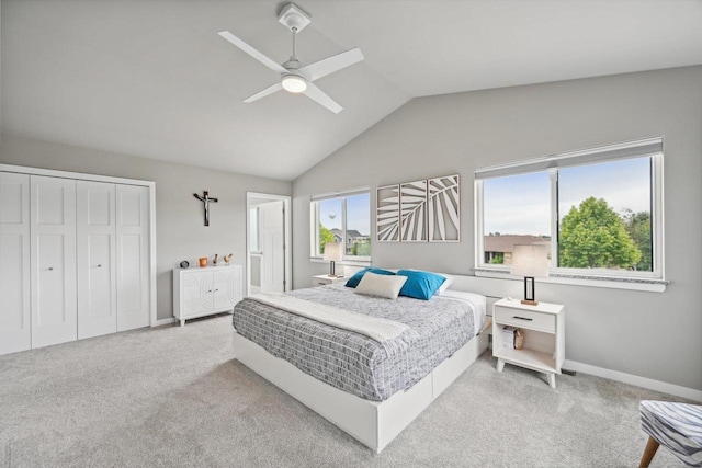 carpeted bedroom with ceiling fan, a closet, lofted ceiling, and multiple windows