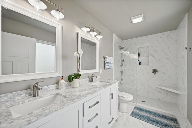 bathroom featuring toilet, vanity, and tiled shower