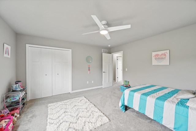 bedroom with ceiling fan, a closet, and light carpet