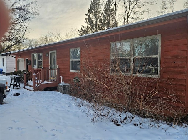 view of snow covered exterior featuring cooling unit