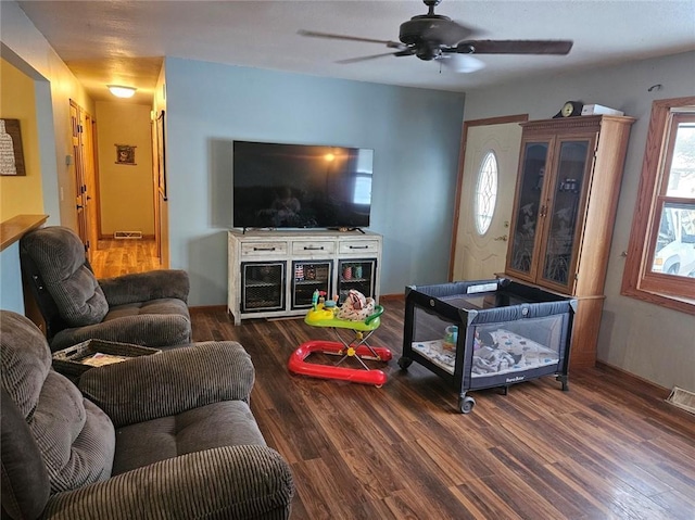 living room with ceiling fan and dark hardwood / wood-style flooring