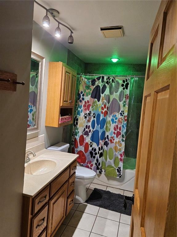 full bathroom with toilet, vanity, tile patterned flooring, and shower / bath combo