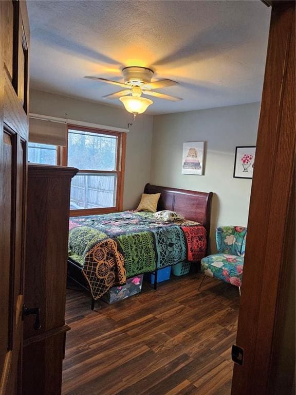 bedroom featuring dark wood-type flooring, ceiling fan, and a textured ceiling