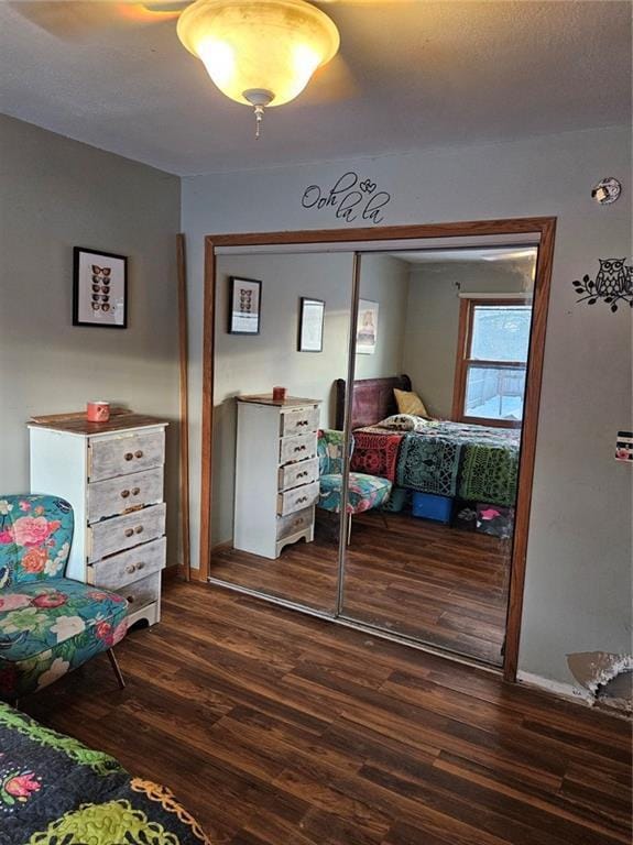 bedroom featuring ceiling fan, a closet, and dark hardwood / wood-style flooring