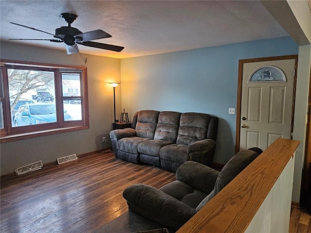 living room featuring a textured ceiling, ceiling fan, and dark hardwood / wood-style flooring