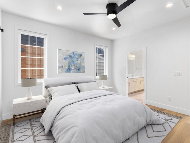 bedroom with ceiling fan, light wood-type flooring, and connected bathroom