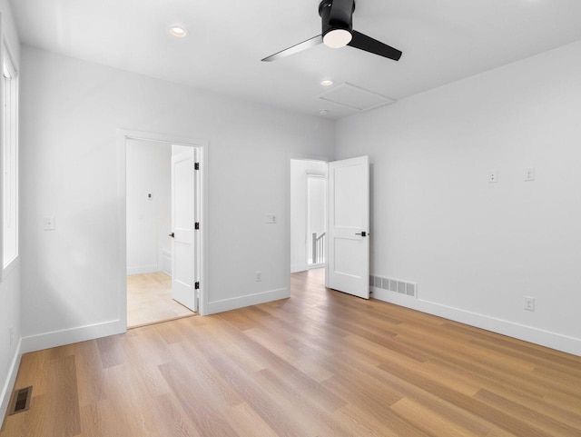 unfurnished bedroom featuring ceiling fan, ensuite bathroom, and light hardwood / wood-style floors