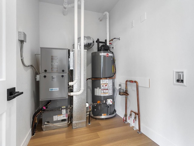 utility room with heating unit and gas water heater