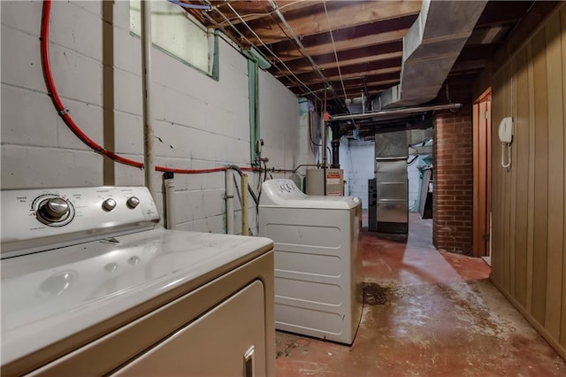 washroom with water heater and separate washer and dryer