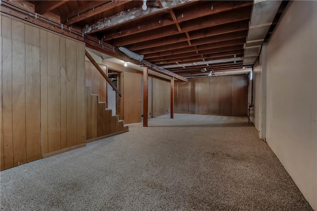 basement with carpet flooring and wooden walls