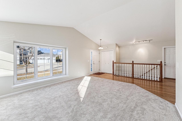 spare room with carpet, lofted ceiling, and a chandelier