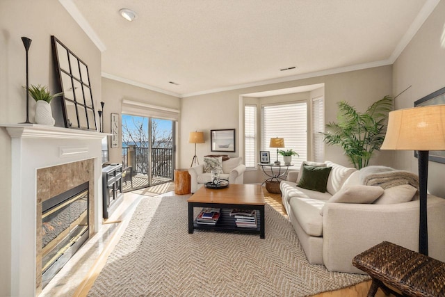 living room with a fireplace, crown molding, and light hardwood / wood-style floors