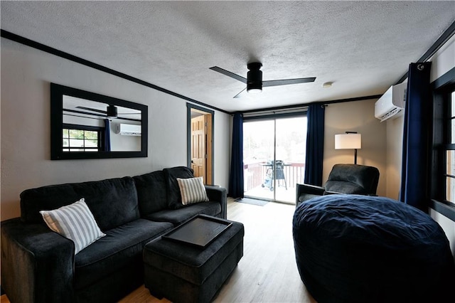 living room with a wall unit AC, a textured ceiling, crown molding, and light hardwood / wood-style floors