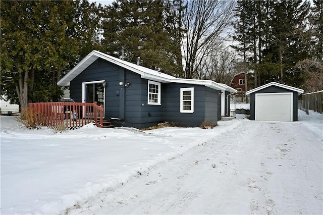 view of front facade featuring a garage, a deck, and an outbuilding