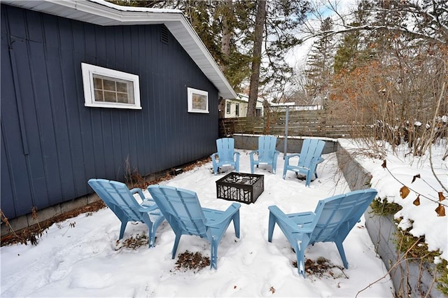 snow covered patio with an outdoor fire pit