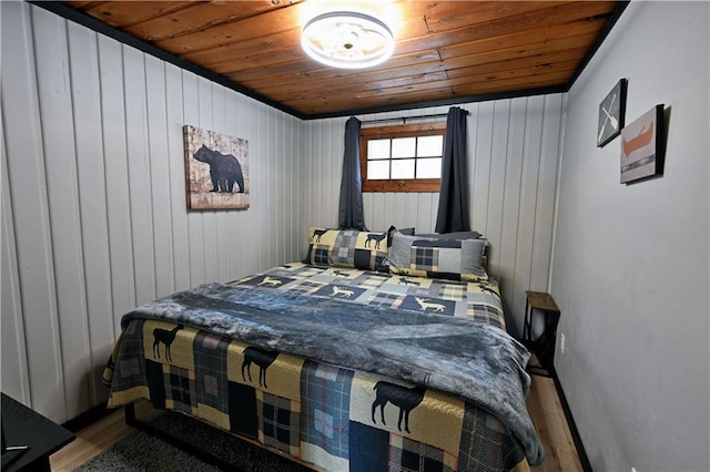 bedroom with wood walls, wooden ceiling, and hardwood / wood-style flooring