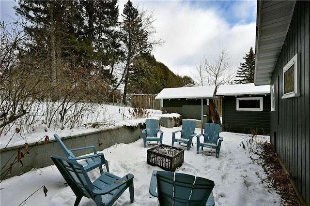 snow covered patio with a fire pit