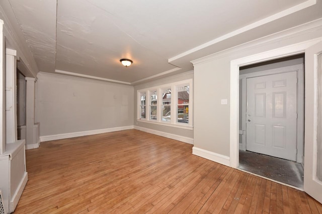 spare room featuring ornamental molding and light hardwood / wood-style floors