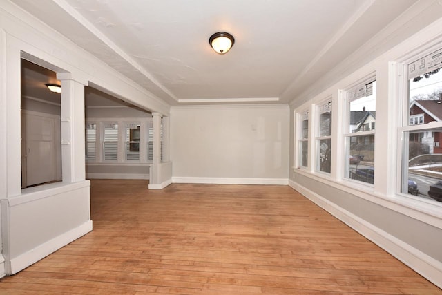 empty room featuring crown molding and light hardwood / wood-style floors