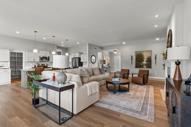 living room featuring ceiling fan and light hardwood / wood-style flooring