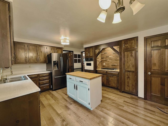 kitchen featuring butcher block countertops, appliances with stainless steel finishes, sink, and dark brown cabinets