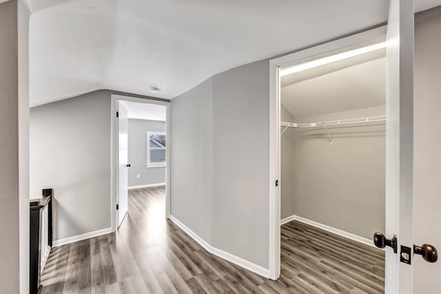 hallway with vaulted ceiling and hardwood / wood-style flooring