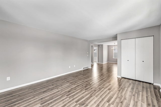 unfurnished bedroom with a closet, a chandelier, and light hardwood / wood-style flooring