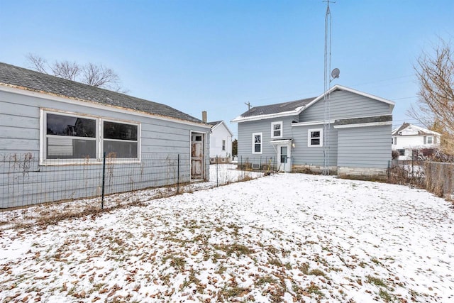 view of snow covered rear of property