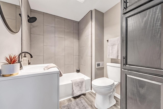 full bathroom featuring hardwood / wood-style flooring, toilet, vanity, and tiled shower / bath combo