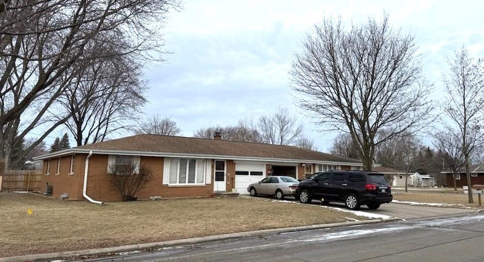 ranch-style home with a garage and a front lawn