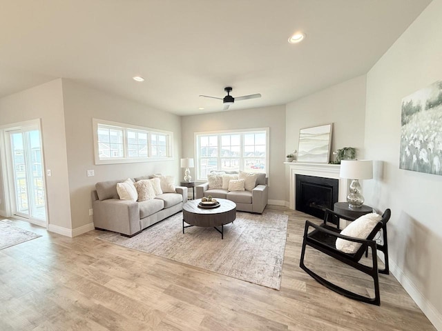 living room with light wood-type flooring and ceiling fan