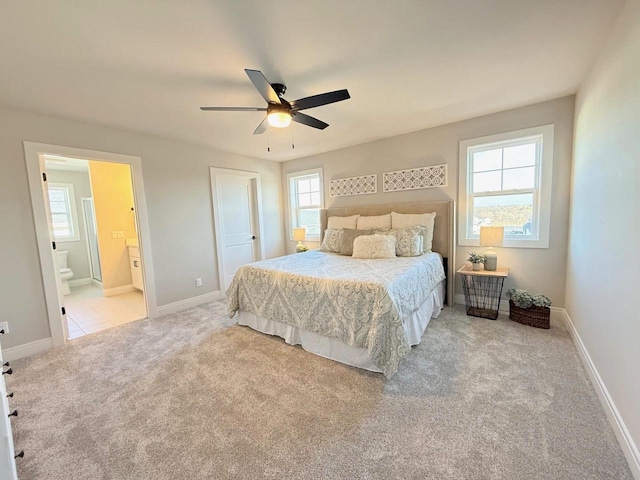 carpeted bedroom with ceiling fan and ensuite bath