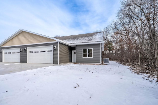 single story home featuring a garage and central air condition unit