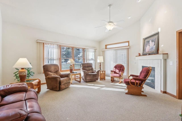 carpeted living room with ceiling fan, a tile fireplace, and vaulted ceiling