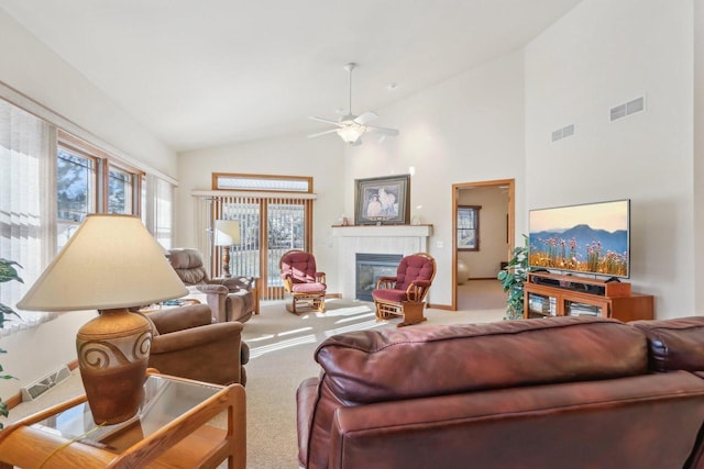 carpeted living room with high vaulted ceiling, ceiling fan, and a tile fireplace