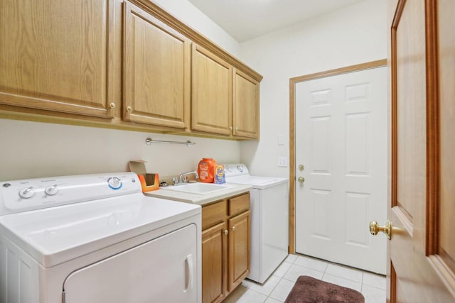 clothes washing area featuring washer and dryer, cabinets, sink, and light tile patterned flooring