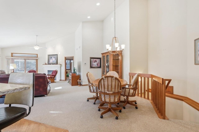 carpeted dining room featuring lofted ceiling and ceiling fan with notable chandelier