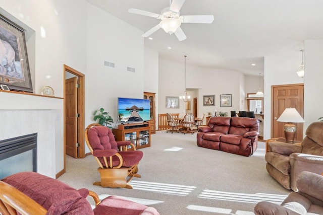 living room featuring high vaulted ceiling, a tile fireplace, light carpet, and ceiling fan