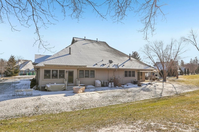 back of property with cooling unit and a yard