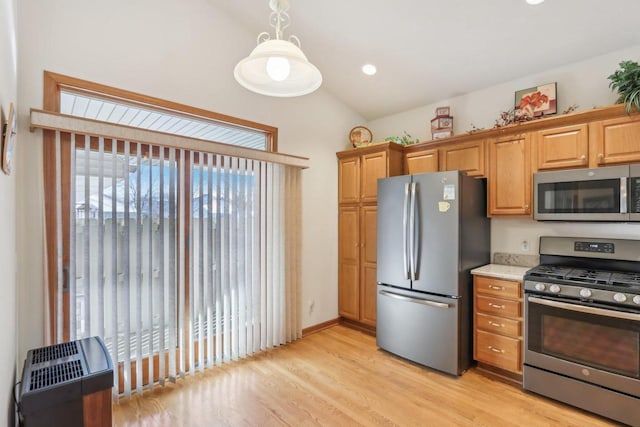 kitchen with decorative light fixtures, appliances with stainless steel finishes, and light hardwood / wood-style flooring