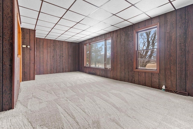 carpeted spare room featuring a paneled ceiling