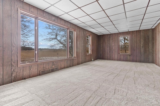 carpeted spare room with a drop ceiling