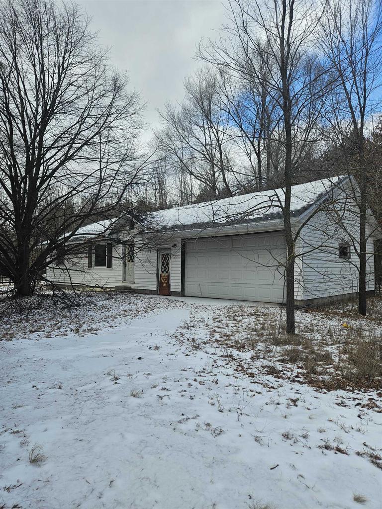 snow covered property featuring a garage