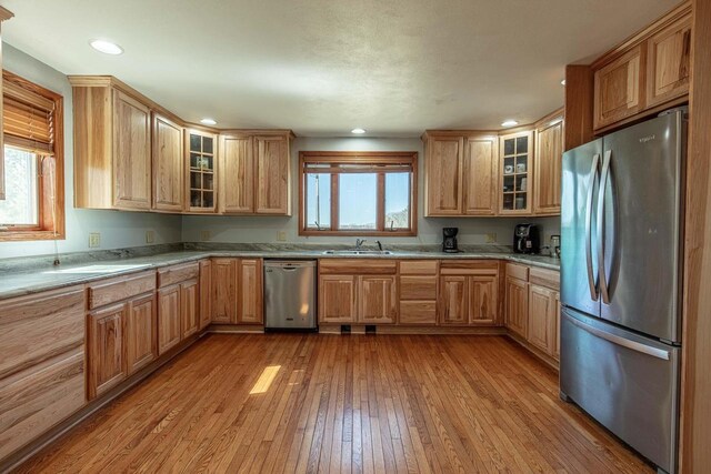 8325 S Avon Store Rd, Brodhead, WI 53520 - kitchen featuring light wood finished floors, glass insert cabinets, recessed lighting, stainless steel appliances, and a sink