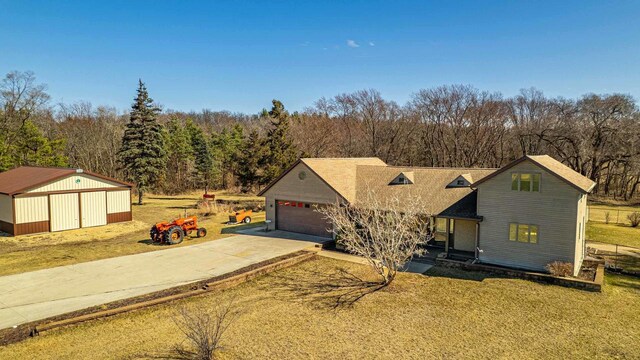 8325 S Avon Store Rd, Brodhead, WI 53520 - view of front of house featuring a garage, a view of trees, a front yard, and driveway