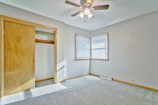 unfurnished bedroom featuring ceiling fan, a closet, and light colored carpet