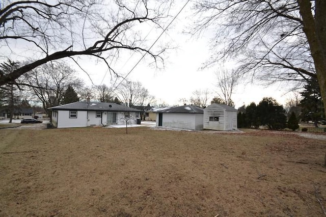 back of property with a yard and a storage unit