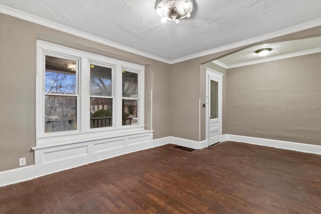 empty room with dark hardwood / wood-style floors and crown molding